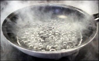 Liquid nitrogen boils in a frying pan on a desk.
