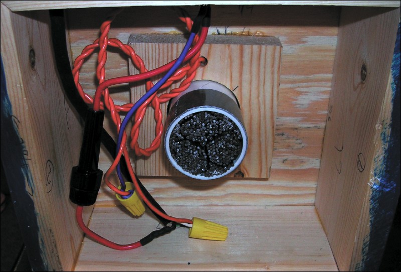 The wiring is complete. The switch is located at the top of the photo. Duct tape has been wrapped around the PVC pipe in order to secure it to the hole in the bottom base board. This particular device has already had its iron core installed.