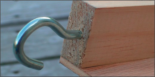 A screw hook has been inserted into the end of one of the 1 × 2 pine boards.